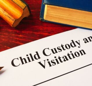 Child Custody and Visitation written on a paper and a book.