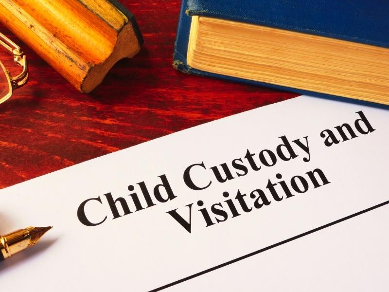 Child Custody and Visitation written on a paper and a book.