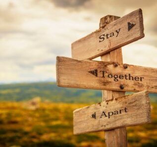 stay together apart text engraved on old wooden signpost outdoors in nature.