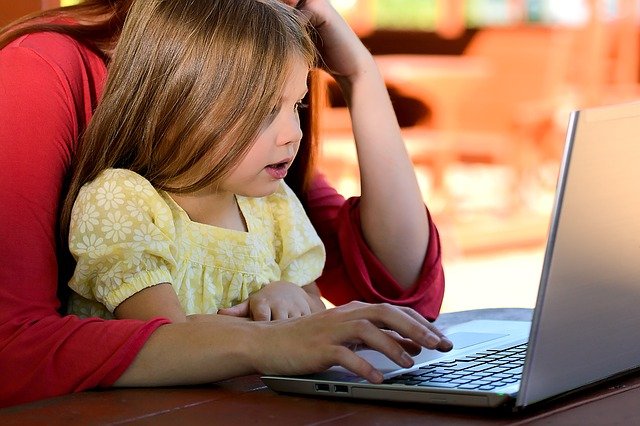 Mom and daughter are looking at computer