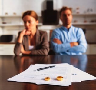 couple sitting at table with divorce documents