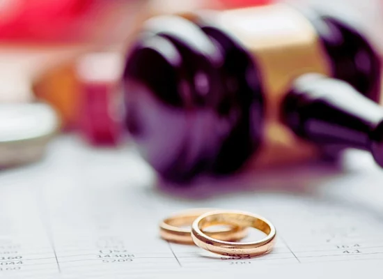 Close up wedding rings with wooden gavel in the background. When an Uncontested Divorce Turns Contested