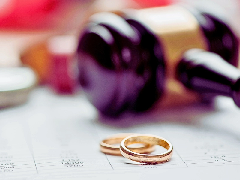 Close up wedding rings with wooden gavel in the background. When an Uncontested Divorce Turns Contested