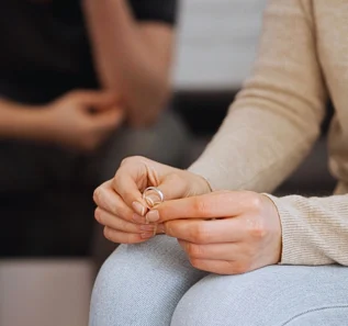 a close-up of a person holding two wedding rings, suggesting a moment of separation or divorce. Get Divorced Without Going to Court