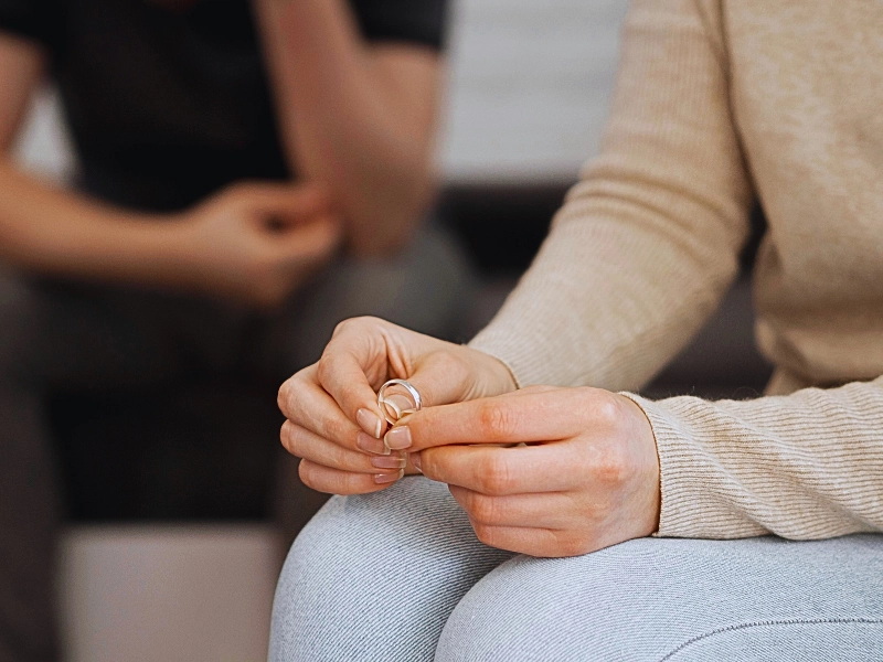 a close-up of a person holding two wedding rings, suggesting a moment of separation or divorce. Get Divorced Without Going to Court